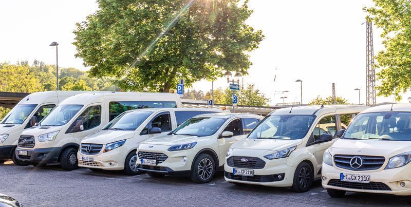 Ein Mann öffnet die Tür eines schwarzen Autos.