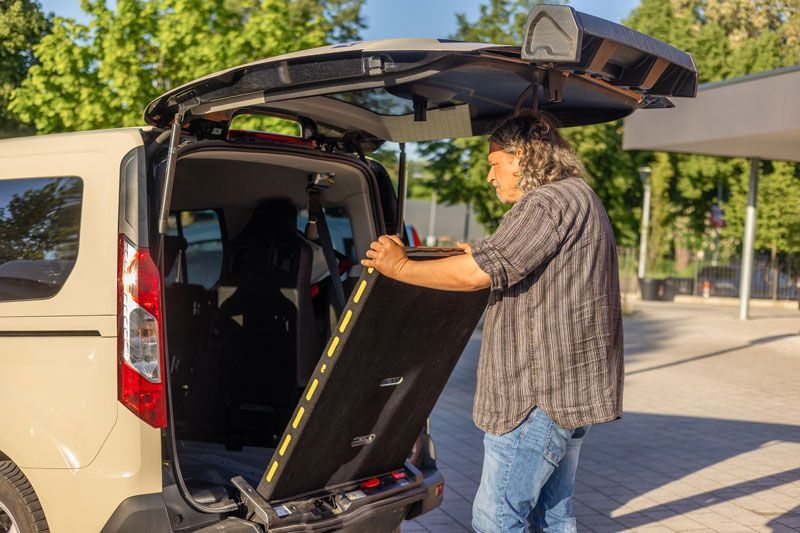 Ein Mann und eine Frau winken einem Taxi am Flughafen zu.