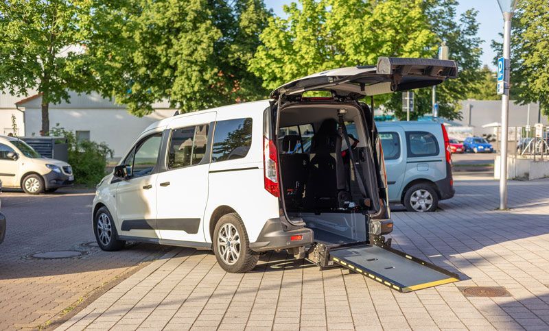 Ein Mann öffnet die Tür eines schwarzen Autos.