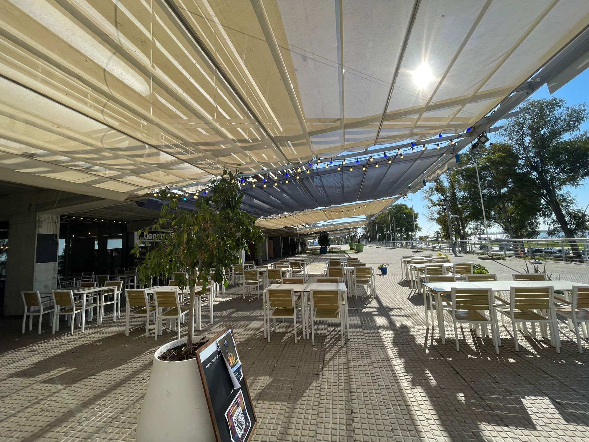 Un restaurante con mesas y sillas bajo un toldo.