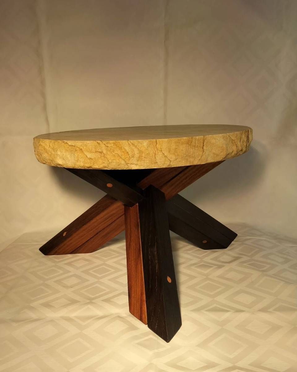 Une table en bois avec un plateau rond et des pieds croisés. Photo D'équerre et d'aplomb