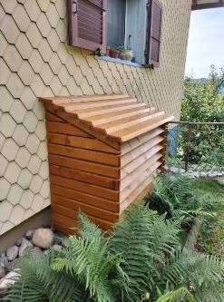 Un coffre en bois à côté d'une maison. Photo D'équerre et d'aplomb