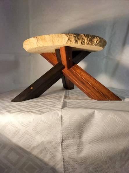 Une table en bois avec un plateau rond et des pieds croisés. Photo D'équerre et d'aplomb