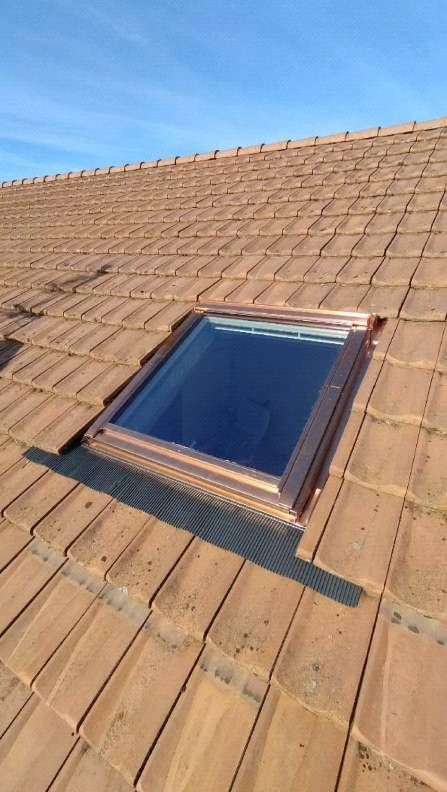 Il y a une lucarne sur le toit d'une maison. Photo D'équerre et d'aplomb