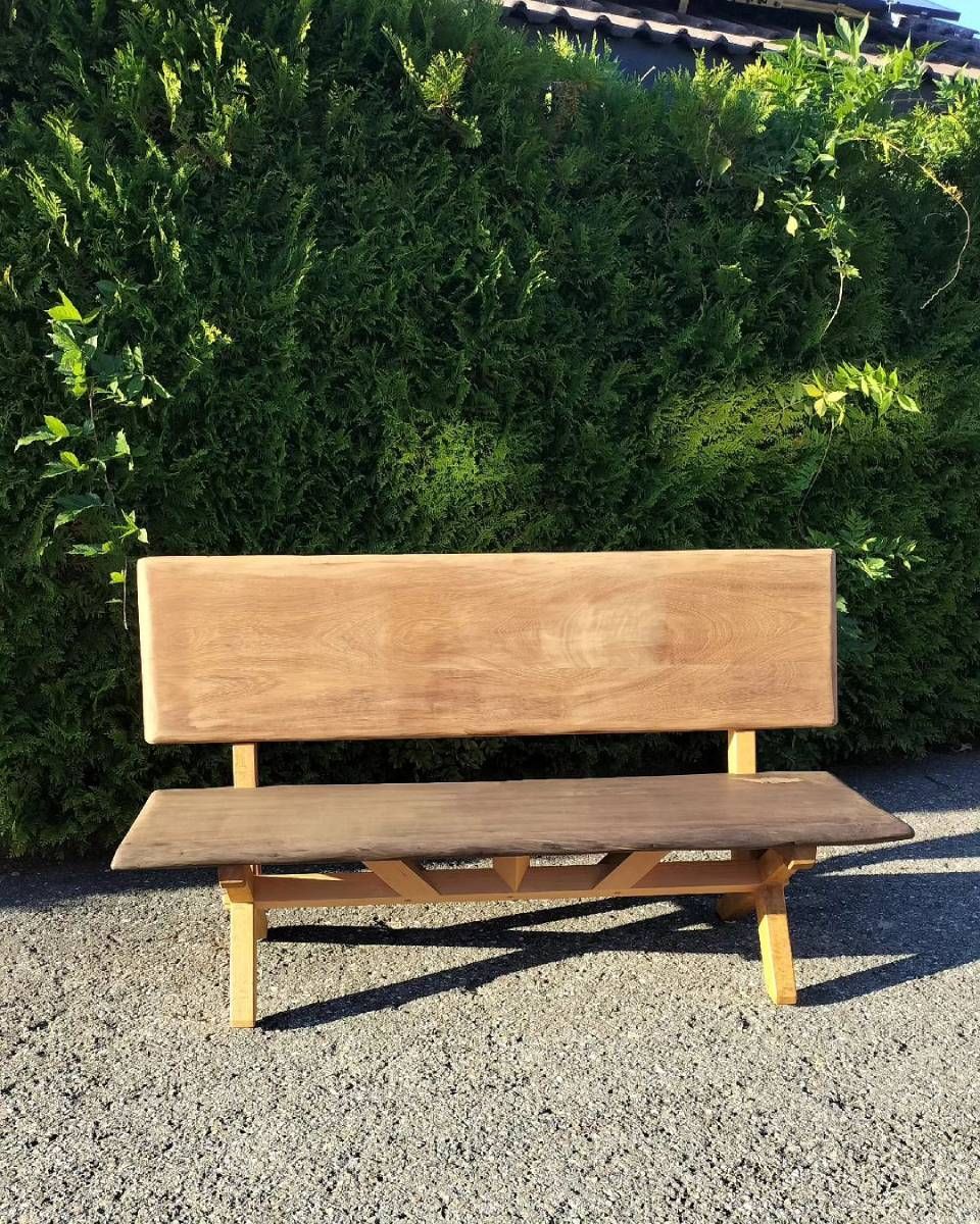 Un banc en bois devant une haie. Photo D'équerre et d'aplomb
