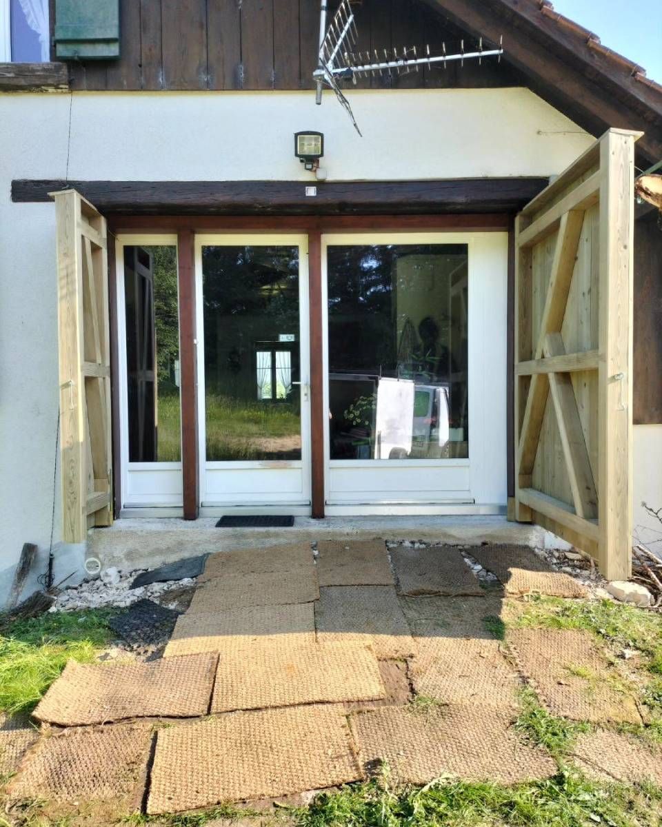 Une maison avec une porte coulissante en verre qui est ouverte. Photo D'équerre et d'aplomb