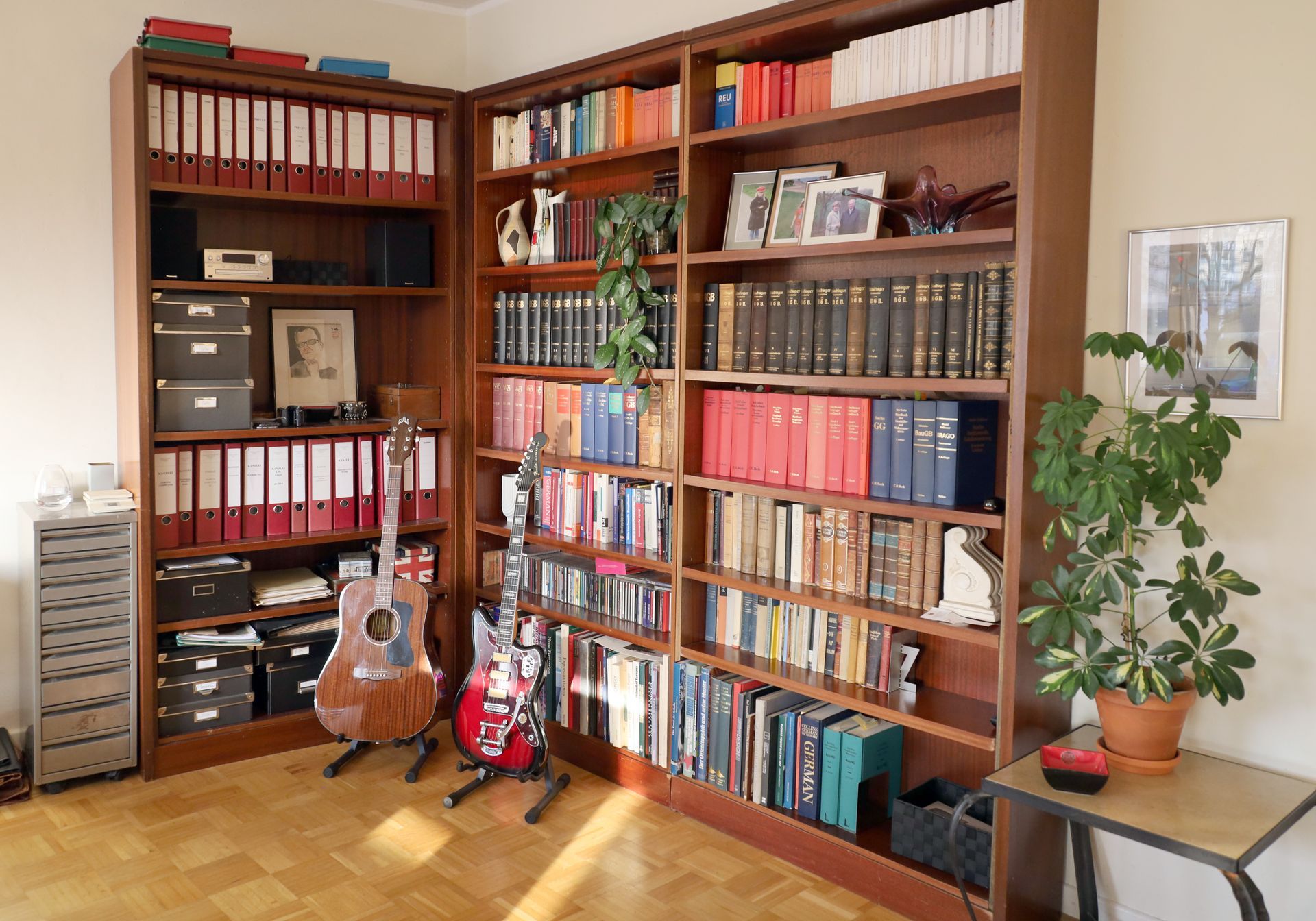 Ein Bücherregal voller Bücher und 2 Gitarren bei der Kanzlei vom Rechtsanwalt Thomas Matthes 