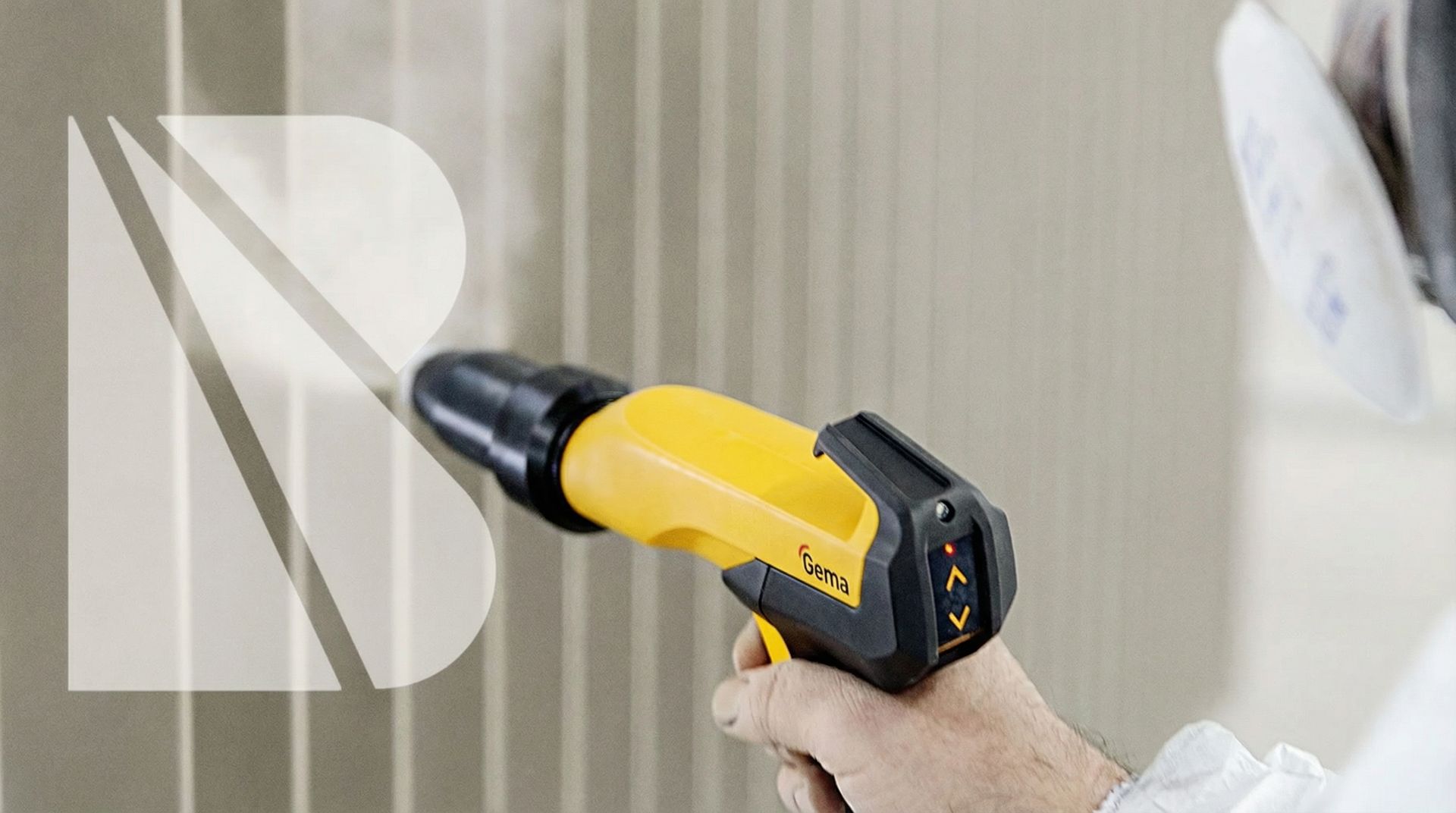 Eine Person, die mit einer gelben Spritzpistole eine Metalloberfläche pulverbeschichtet und dabei eine Atemschutzmaske trägt.