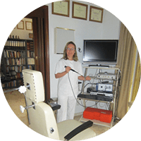 Un médico con bata blanca sostiene un instrumento médico cerca del equipo en el consultorio.