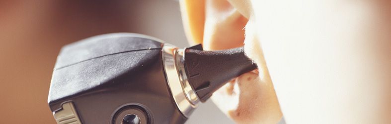 Se utiliza un otoscopio para examinar el oído del paciente de cerca. El médico lo sostiene.