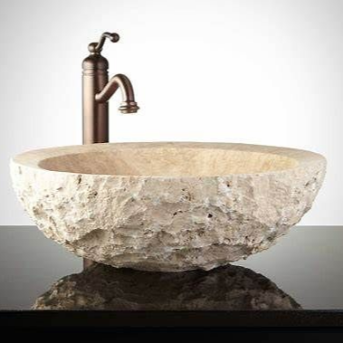 Vasque en pierre brute avec robinet en bronze.