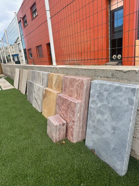 Loupe à manche en corne posée sur deux livres, fond en carrelage sombre et moucheté.