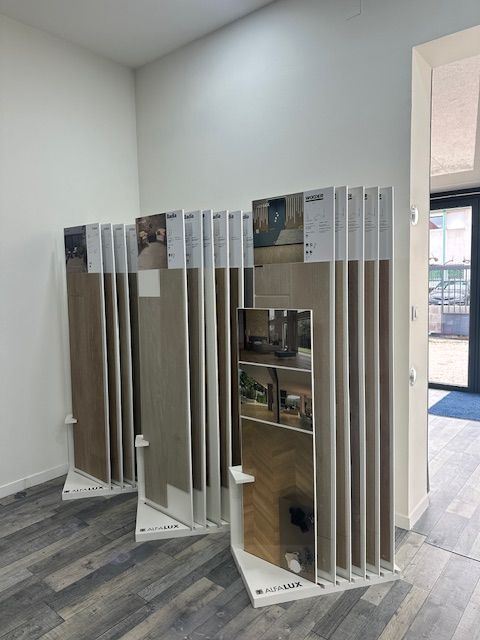 Une salle d'exposition de carrelage présentant divers échantillons dans un décor aux tons neutres.