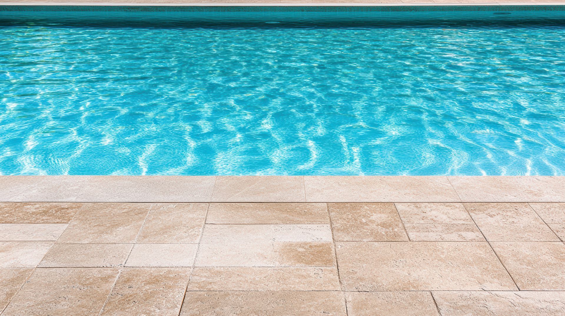 Piscine aux eaux turquoise et aux bords carrelés de pierre claire.