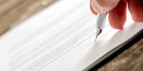 Una persona está firmando un documento con una pluma fuente.
