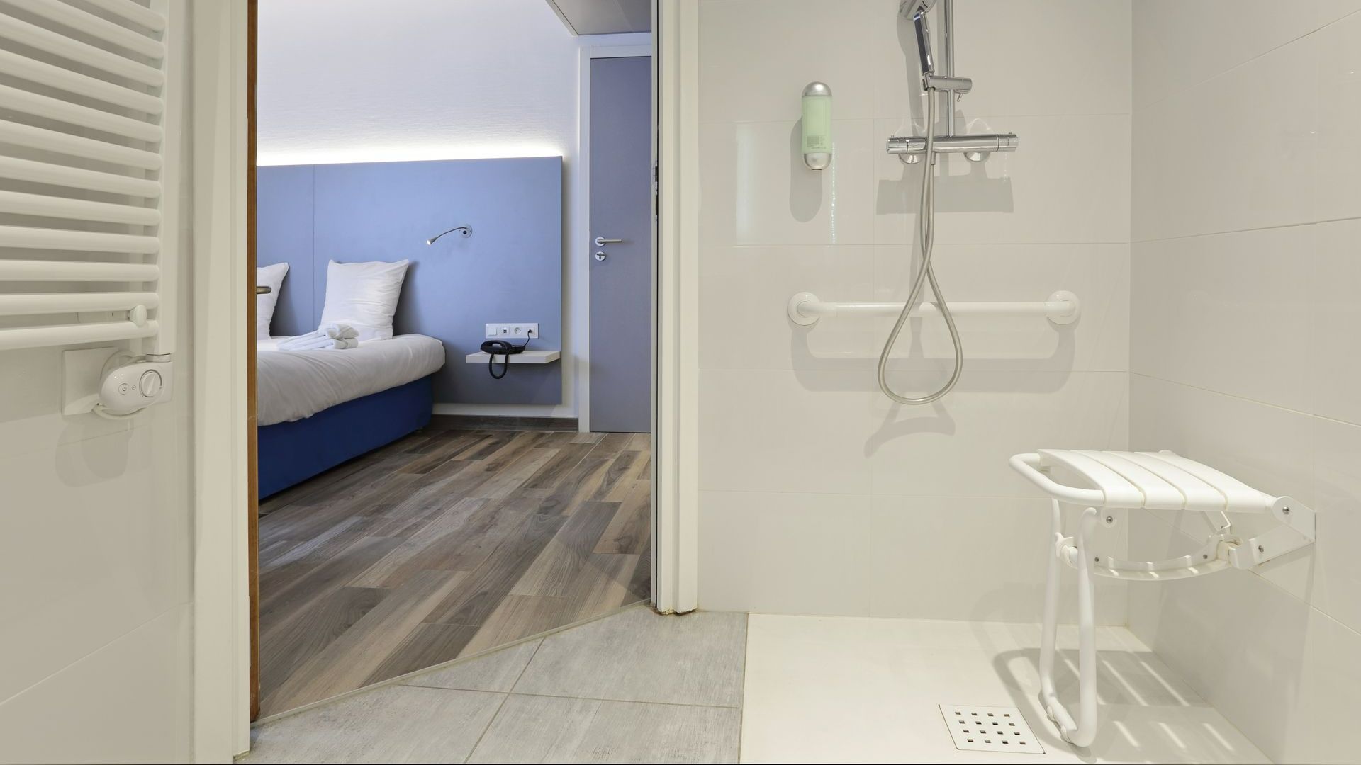 Image prise depuis une salle de bains PMR donnant sur une chambre