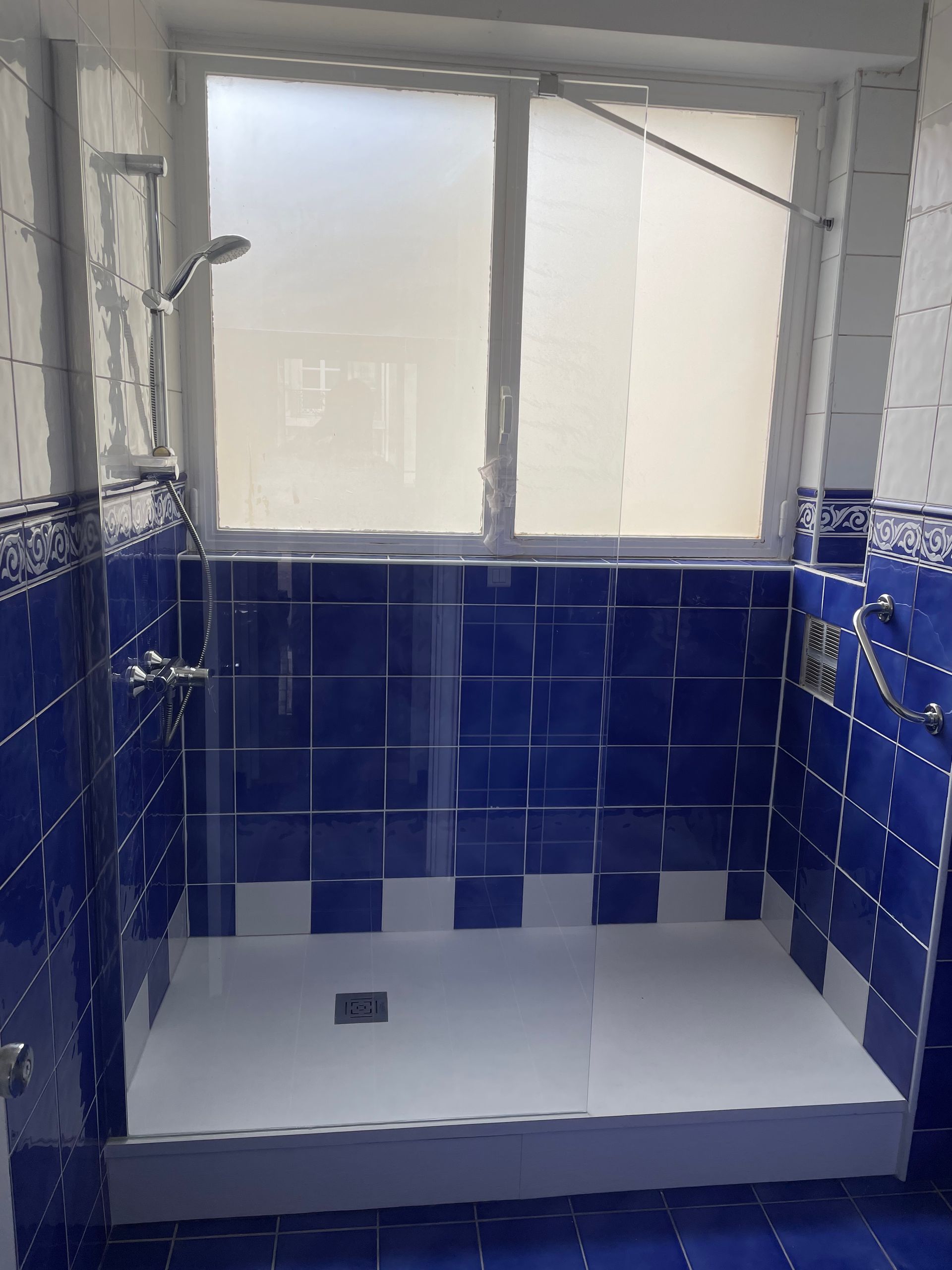 Douche à l'italienne dans une salle de bains bleue.