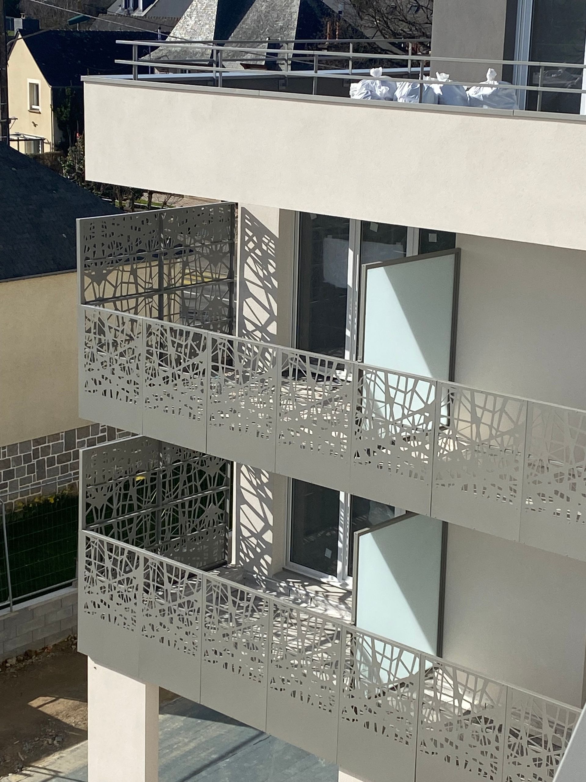 Immeuble d'appartements moderne avec balustrades de balcon décoratives en métal.