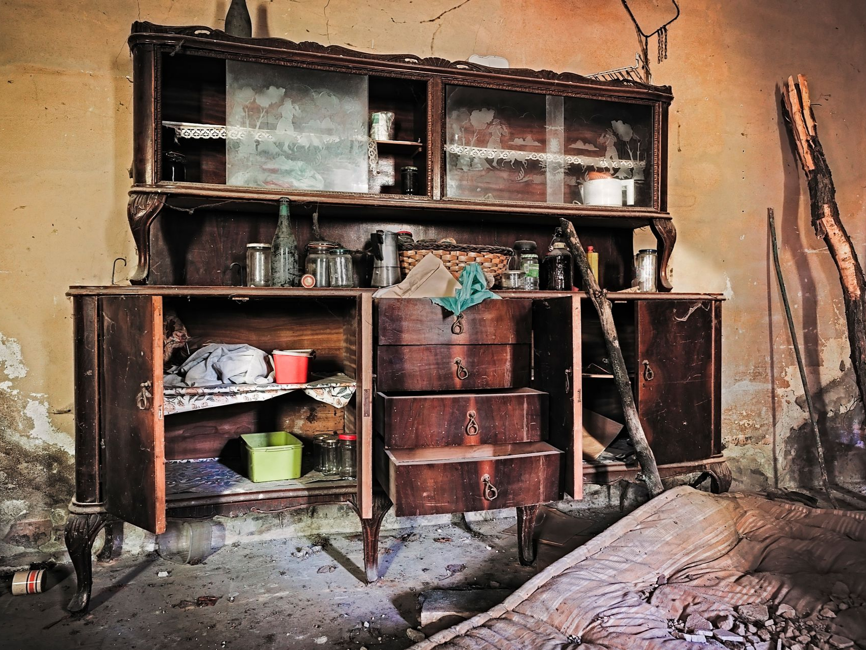 Un meuble délabré dans une pièce en très mauvais état.