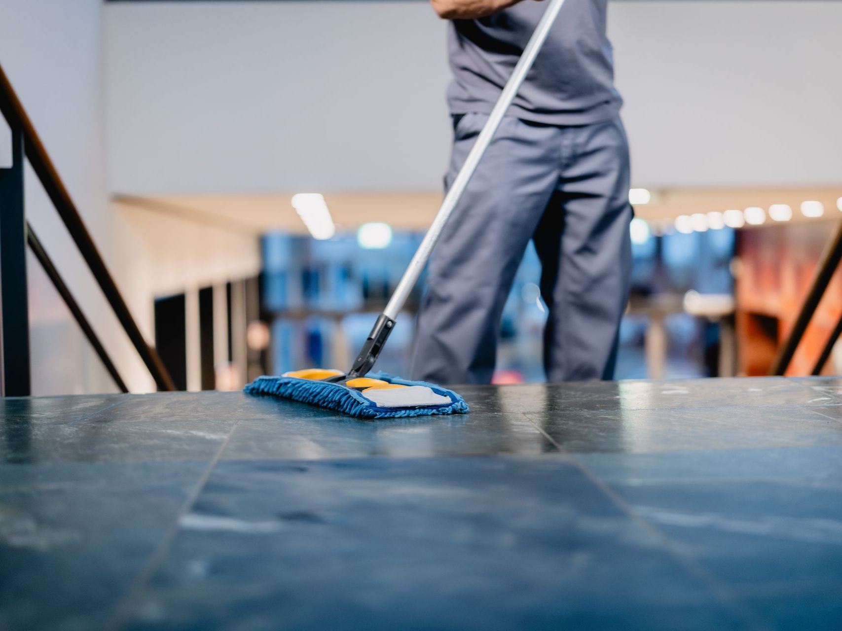 Une personne qui nettoie un sol à l'aide d'un lavage à plat.