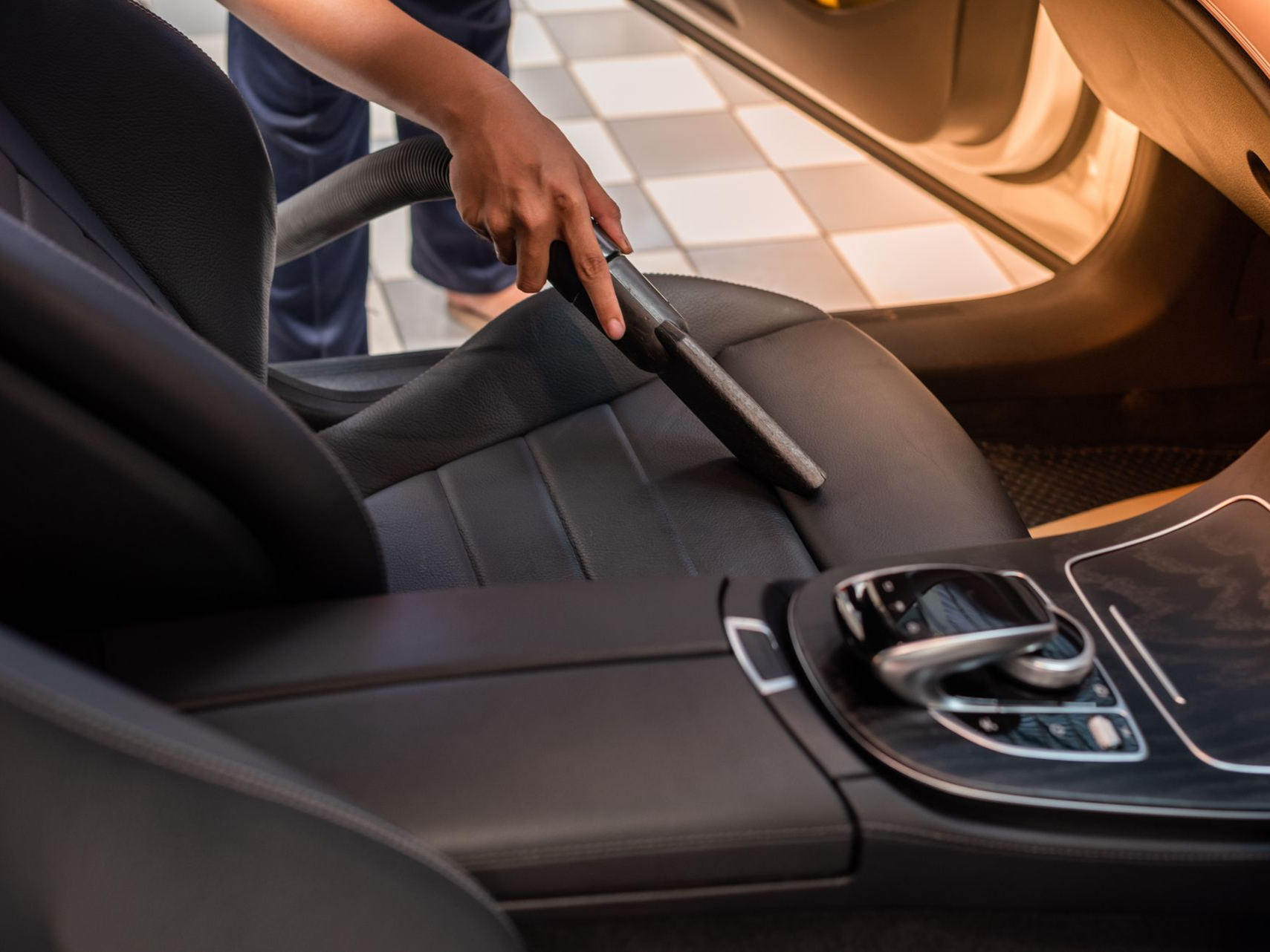 Une personne aspire un siège de voiture.