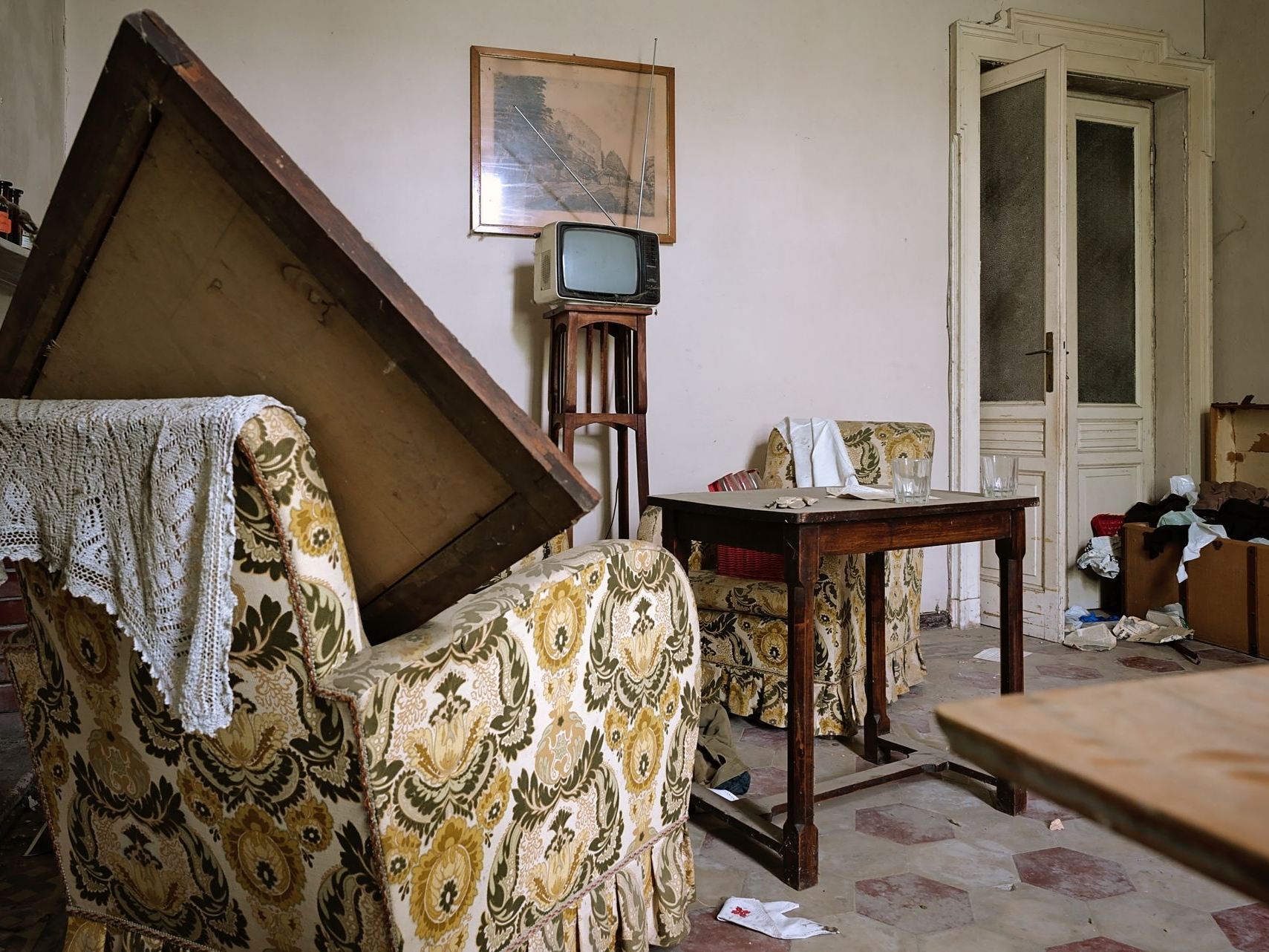 Un salon avec du vieux mobilier endommagé.