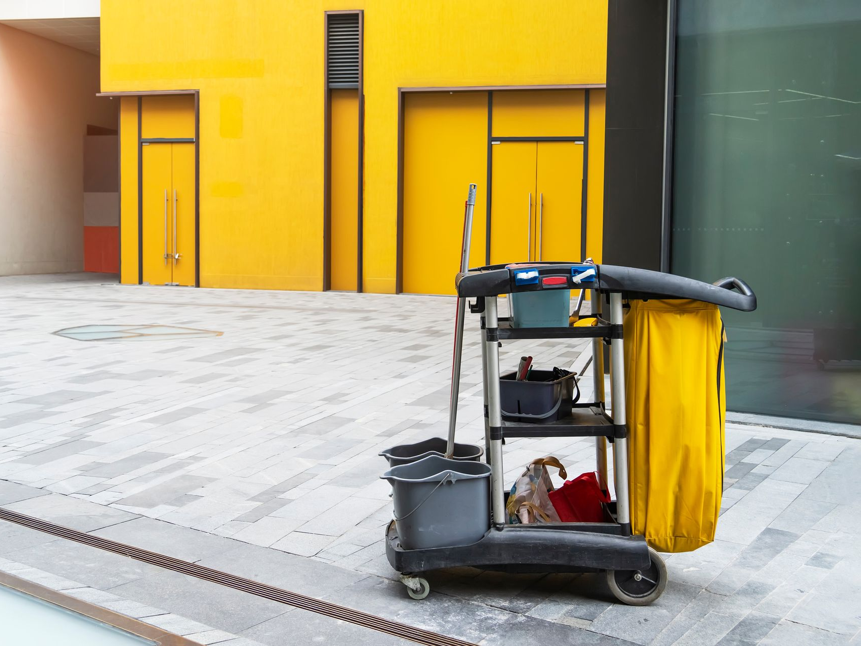 Un chariot de nettoyage professionnel devant des locaux.