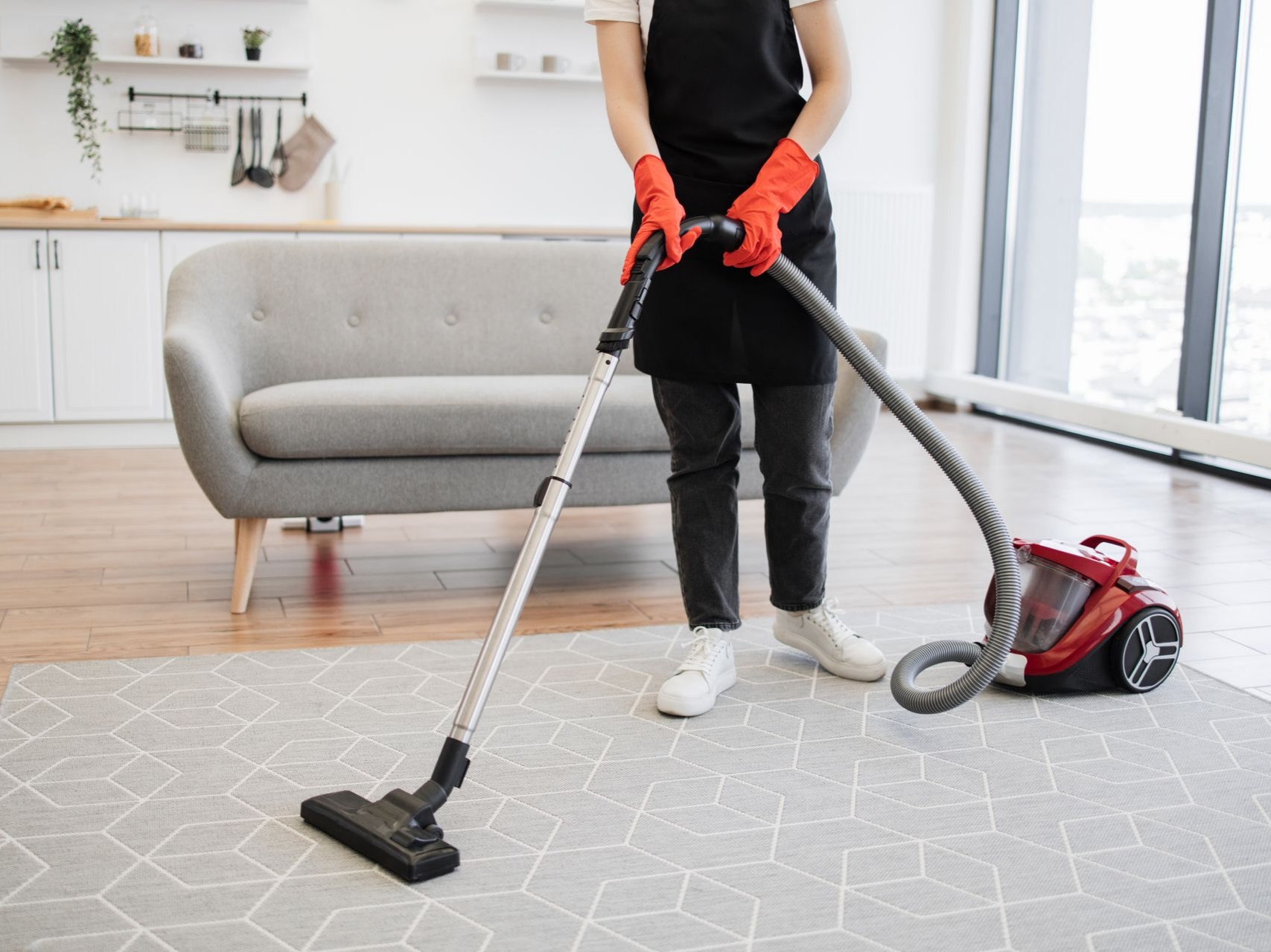 Une personne qui passe l'aspirateur sur un tapis.