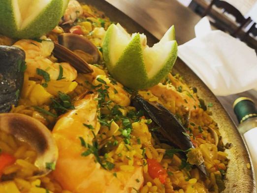 Un primer plano de un plato de comida con camarones, mejillones y arroz.