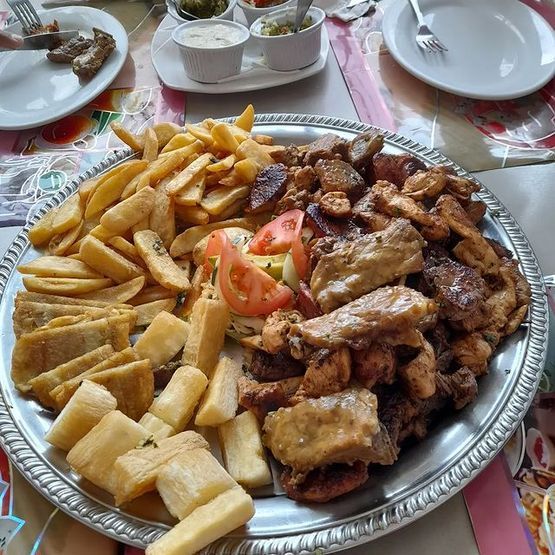 Un plato de comida con patatas fritas y carne en una mesa.