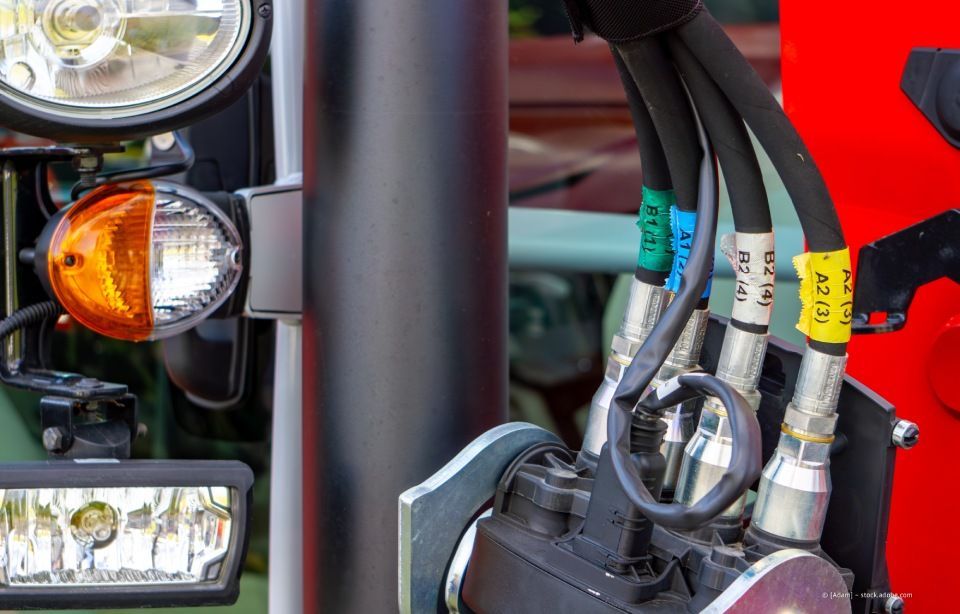 Industrieller Pumpenraum mit blauen Pumpen und großen Rohren entlang eines gefliesten Korridors