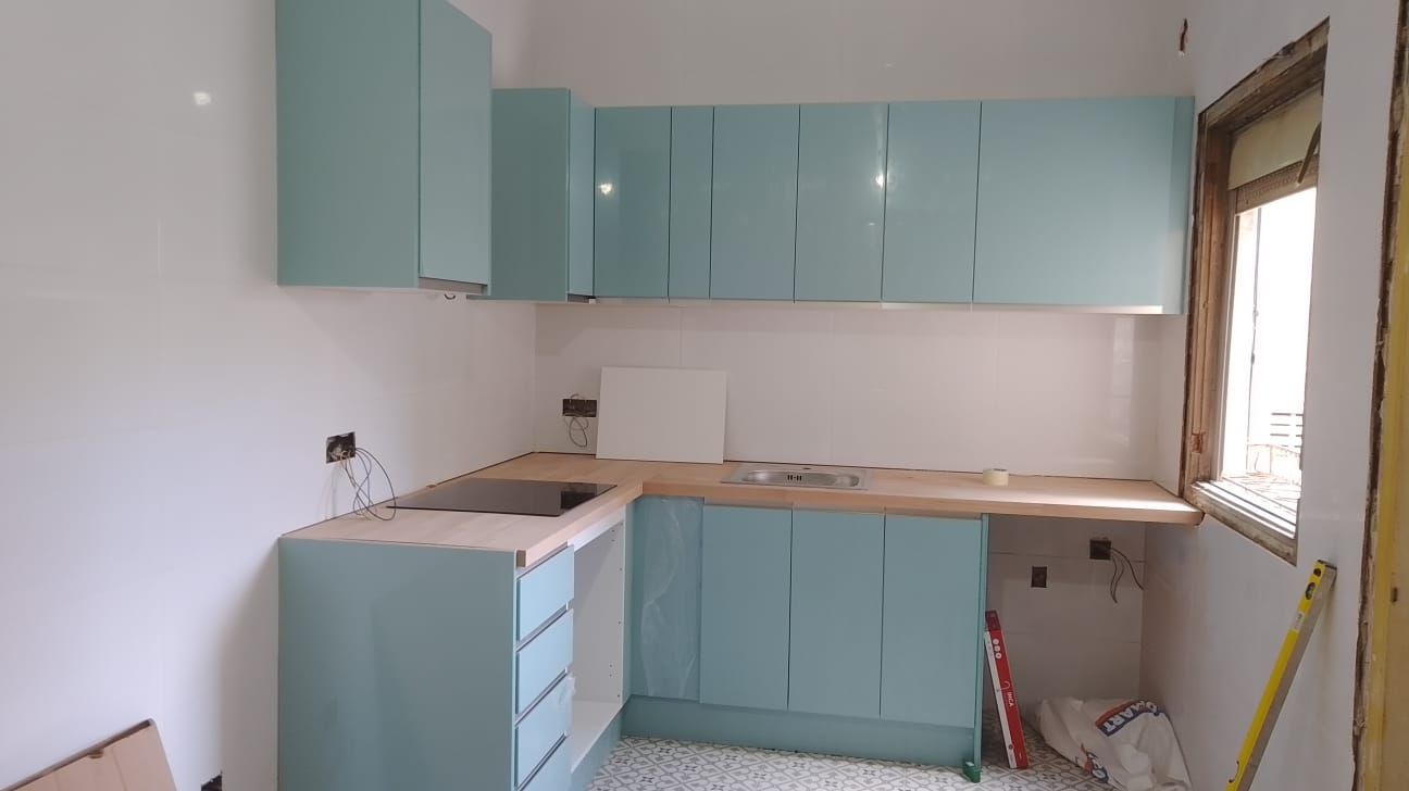 Una cocina con gabinetes azules y una cinta métrica amarilla.