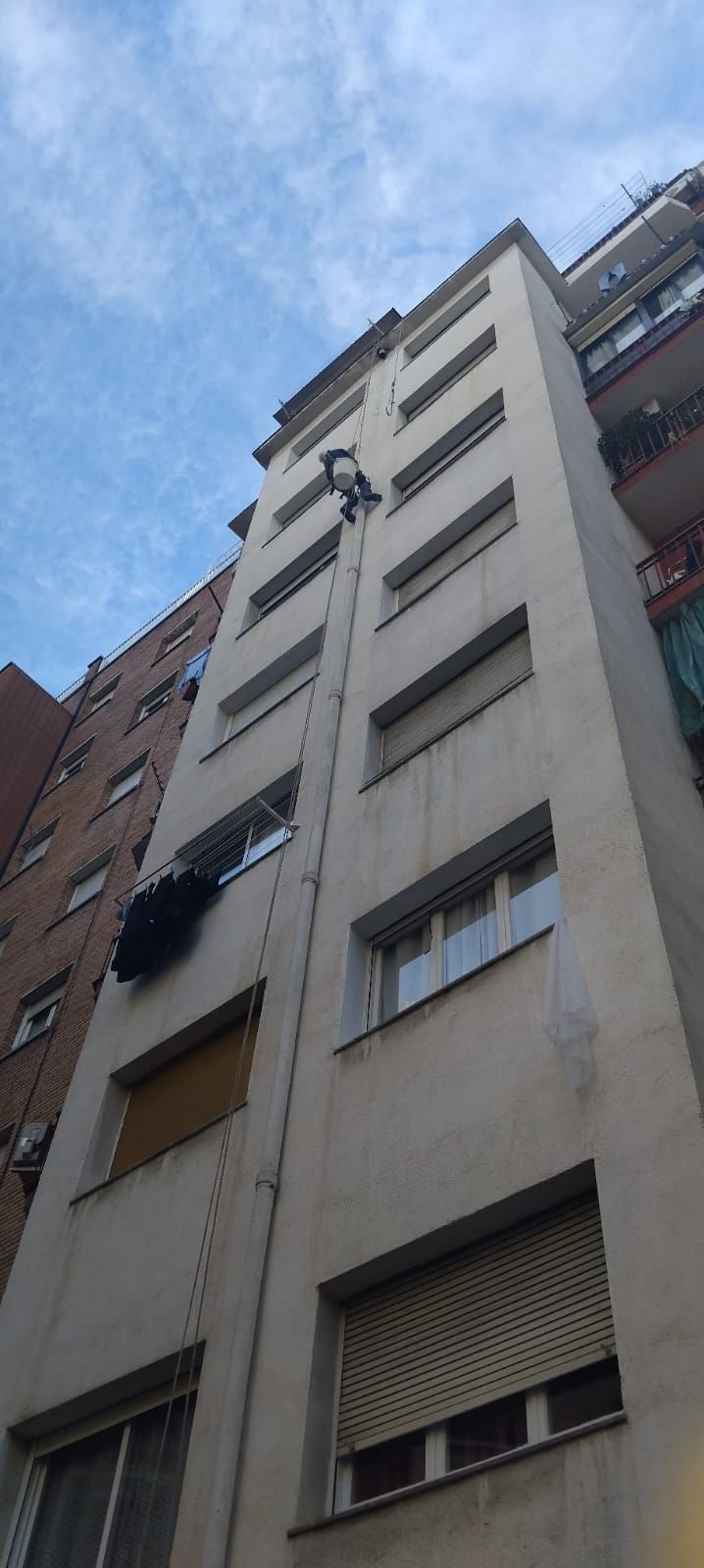 Mirando hacia arriba a un edificio alto con un cielo azul de fondo