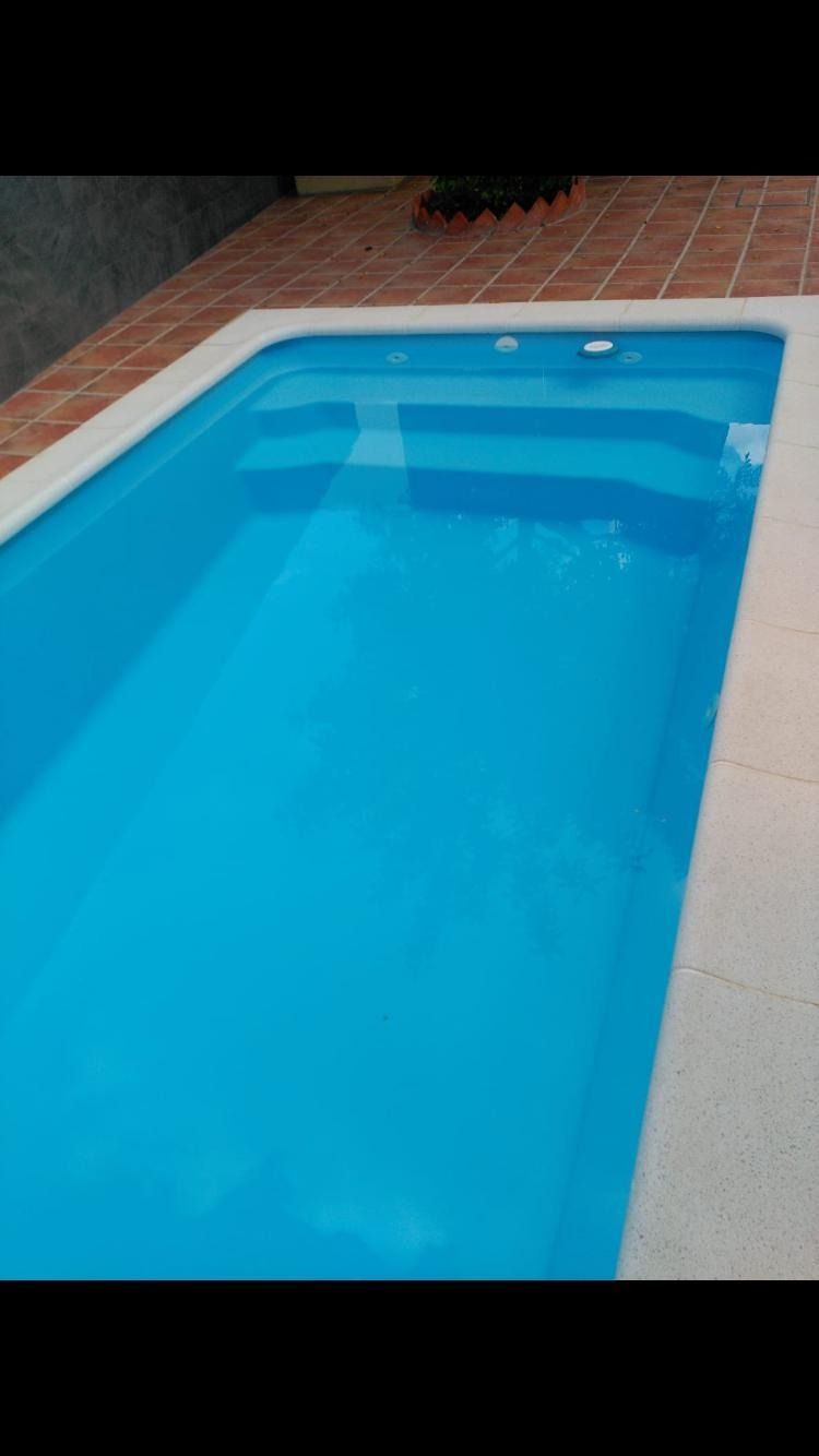 Una gran piscina llena de agua azul se encuentra sobre un suelo de baldosas.