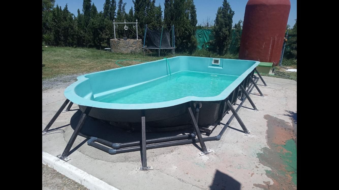 Una gran piscina está situada encima de un campo de tierra.