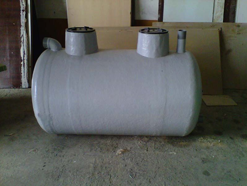 Un gran tanque blanco está sentado sobre un piso de cemento.