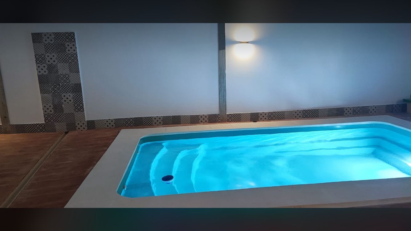 Una pequeña piscina con agua azul en una habitación.