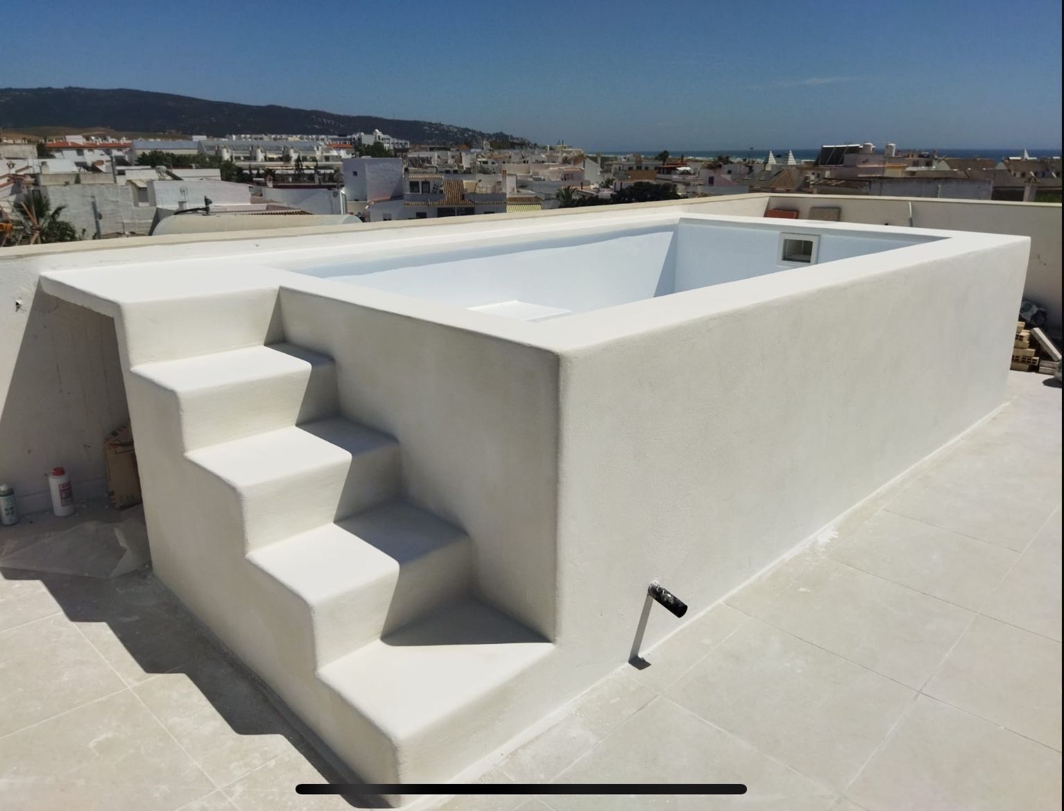 Una gran piscina blanca con escaleras que conducen a ella.