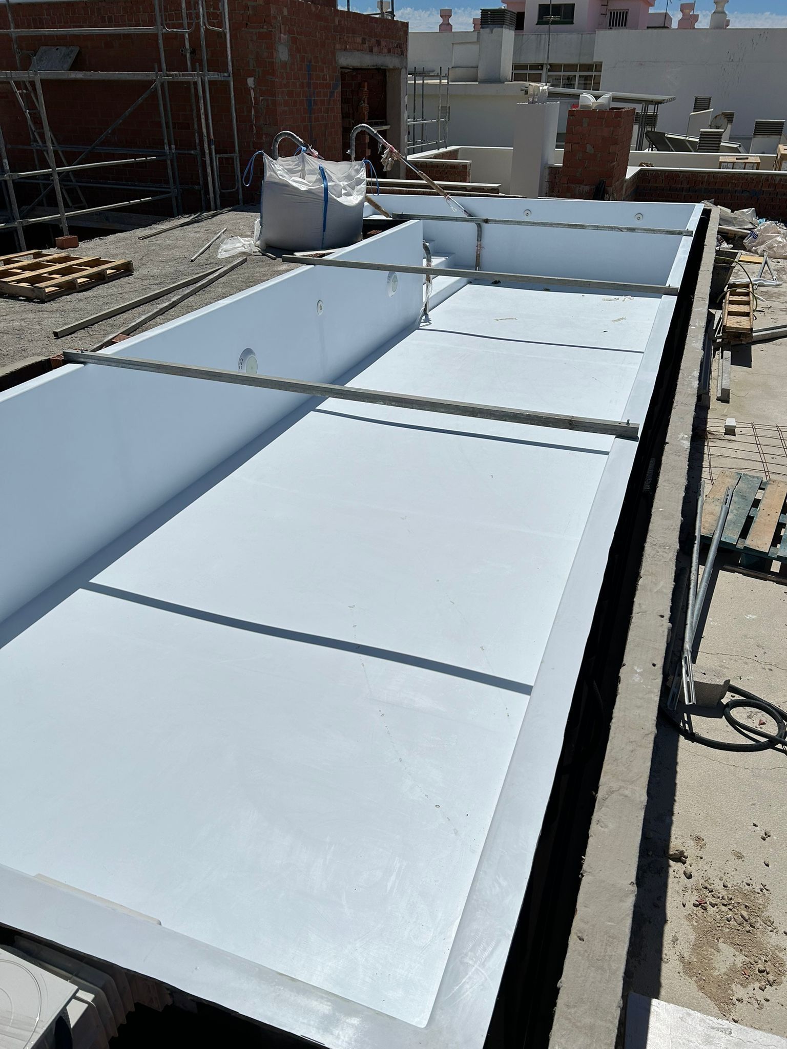Se está construyendo una gran piscina blanca en el tejado de un edificio.