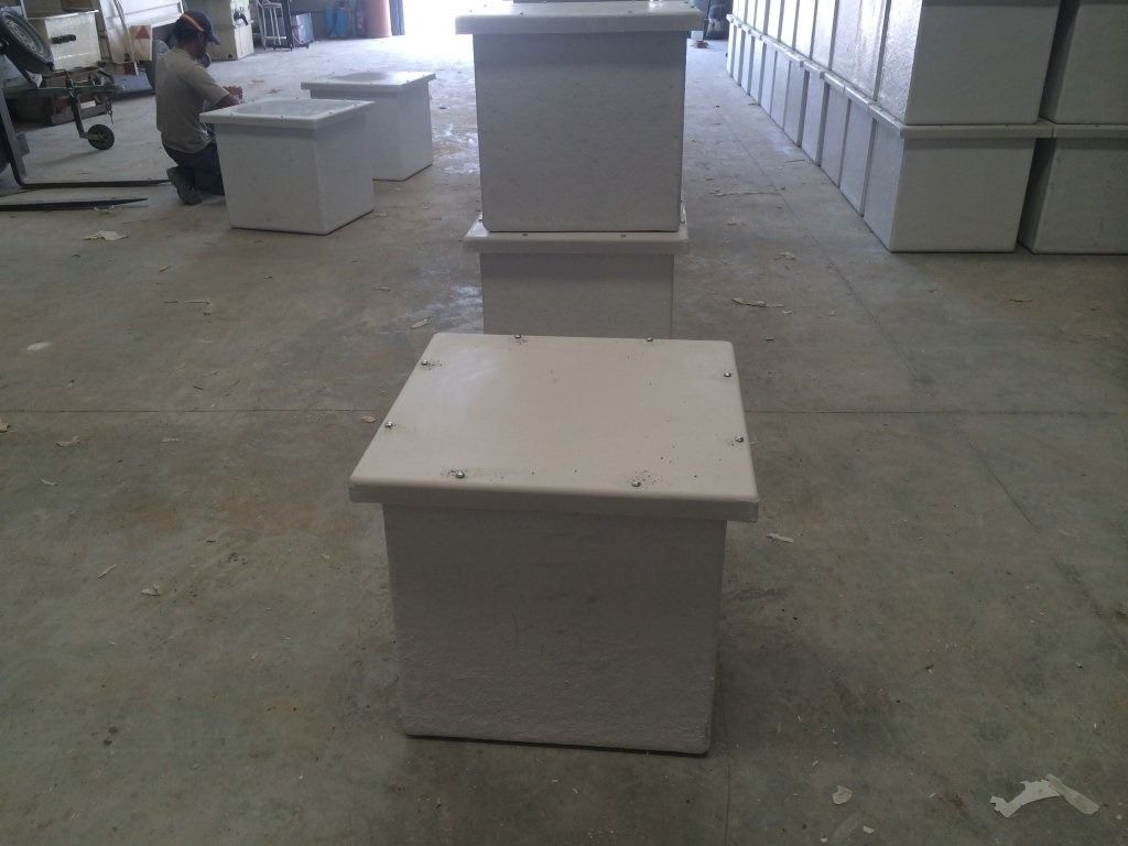 Tres cajas blancas están apiladas una encima de otra en un almacén