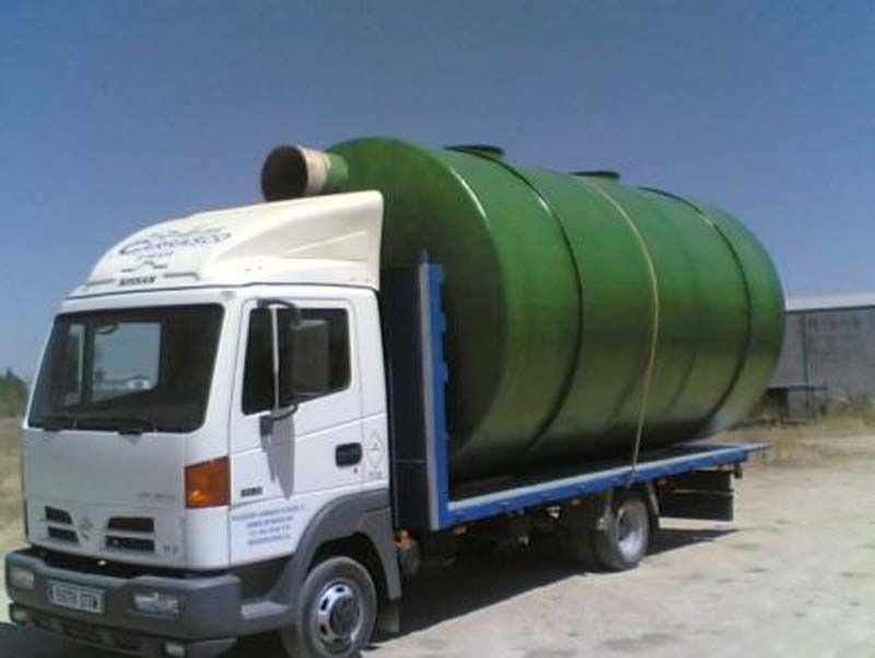 Un camión blanco con un gran tanque verde en la parte trasera.