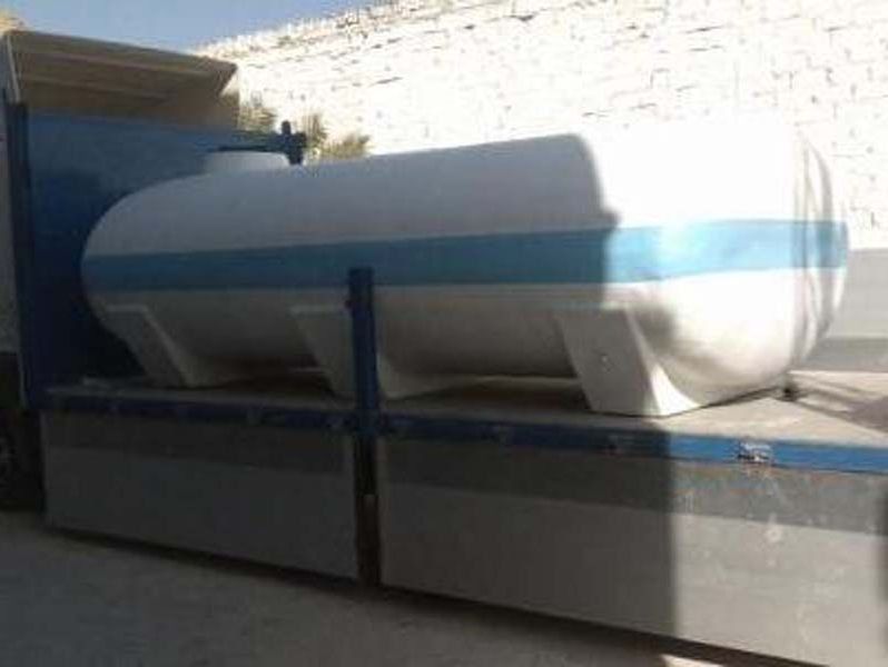 Un gran tanque blanco está sentado encima de un camión.