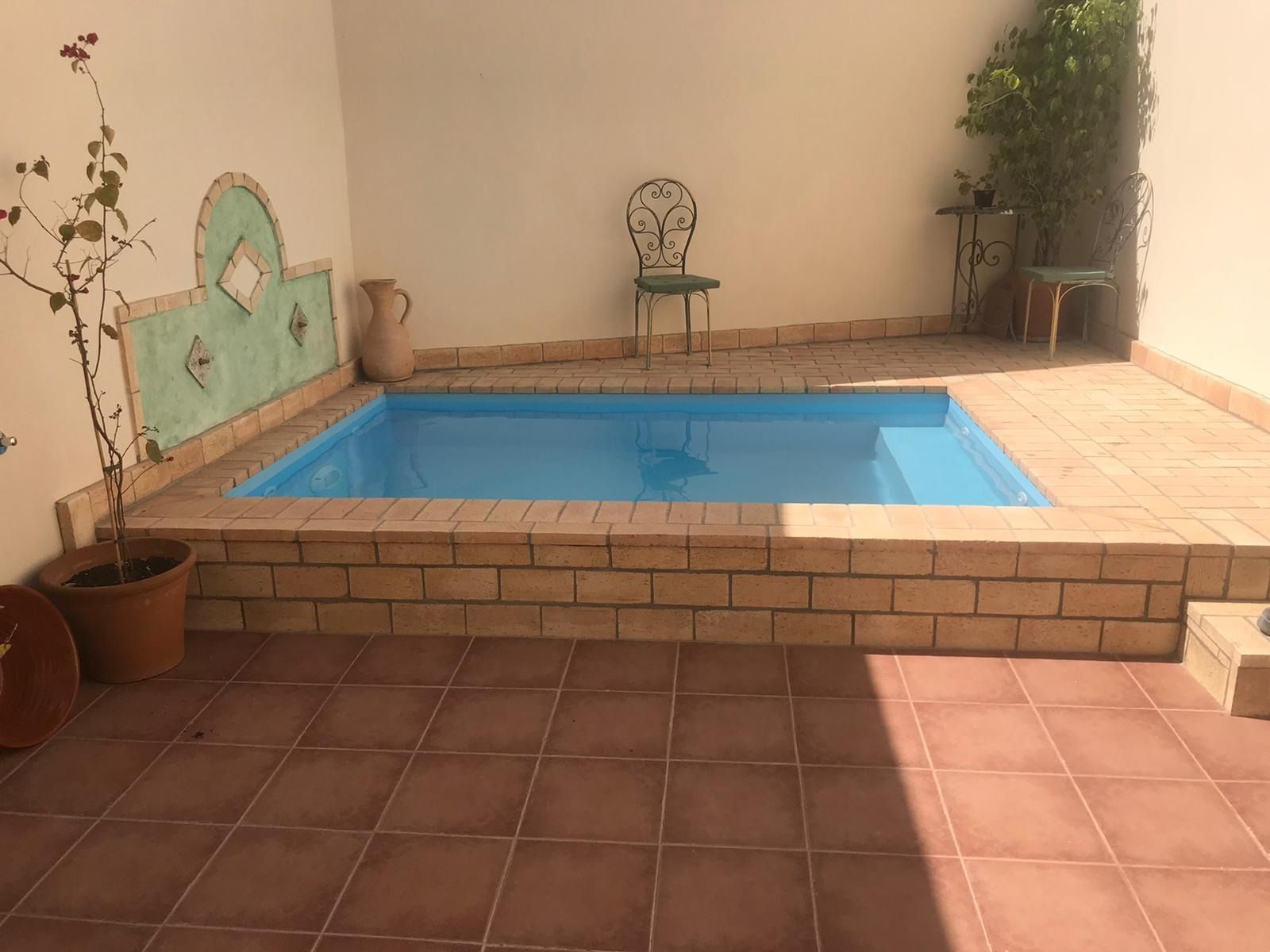 Hay una pequeña piscina en el medio de un patio.