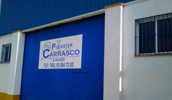 Un edificio azul y blanco con un cartel que dice poliéster carrasco.