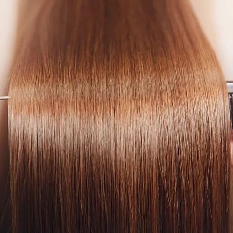Un primer plano del cabello de una mujer con una plancha.