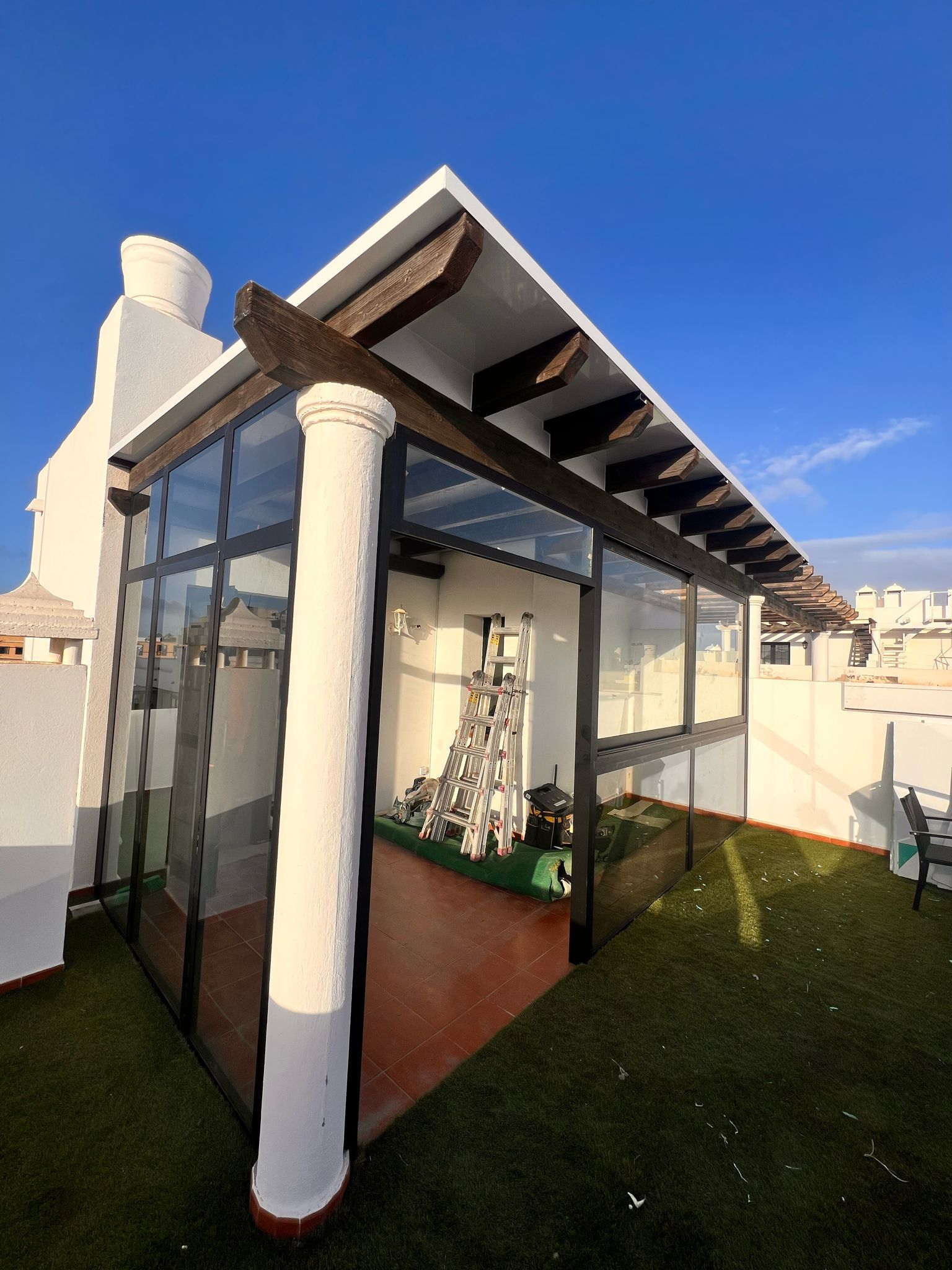Un edificio blanco con una pérgola encima.