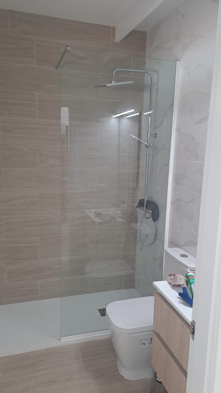 Un baño con inodoro, lavabo y ducha.