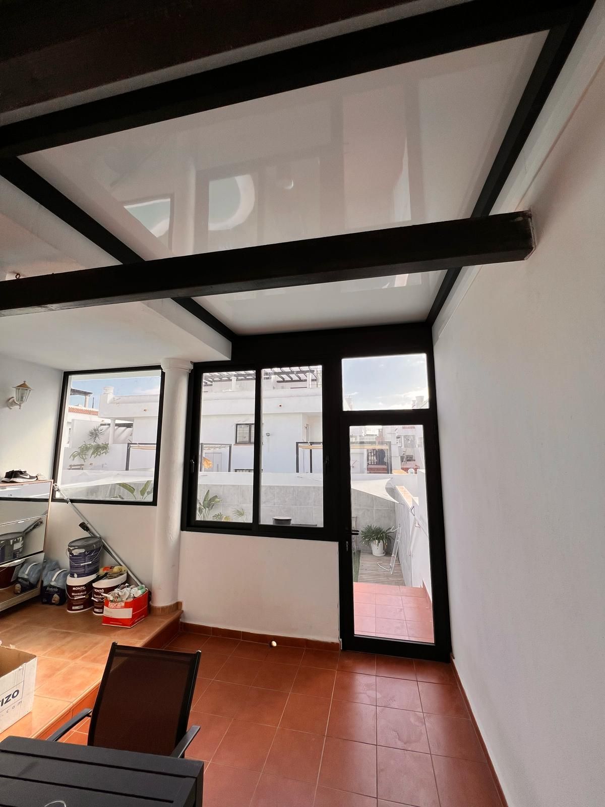 Una habitación con muchas ventanas y una mesa.