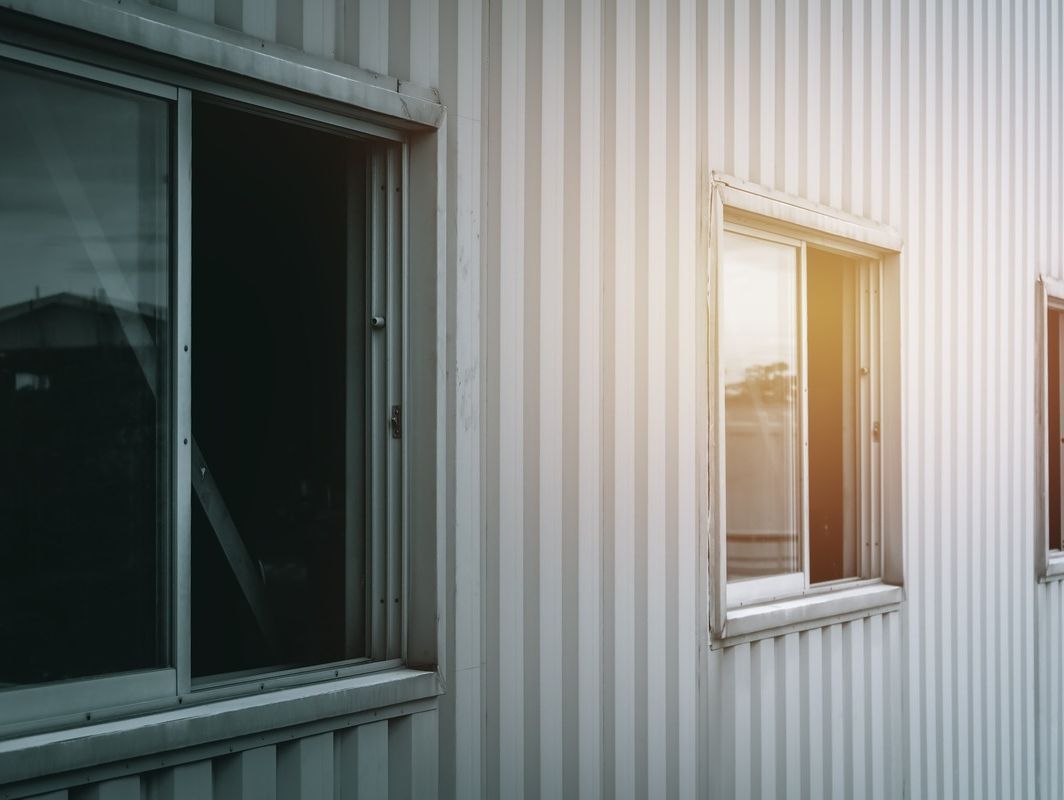 El sol brilla a través de las ventanas del lateral de un edificio.