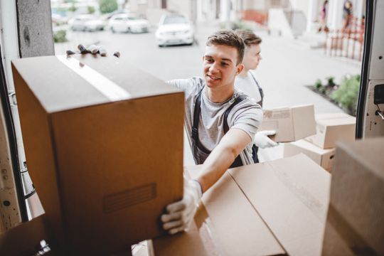 Umzugsleute entladen Umzugskartons